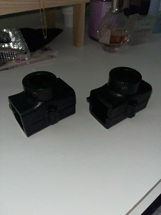 Two black plastic cameras sitting on top of a table.